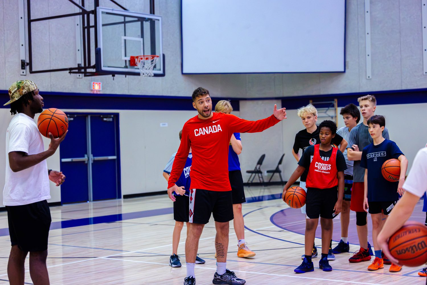 Team Canada guard Jadon Cohee coaching a group of Junior Coyotes players at Fall Tip-Off 2026